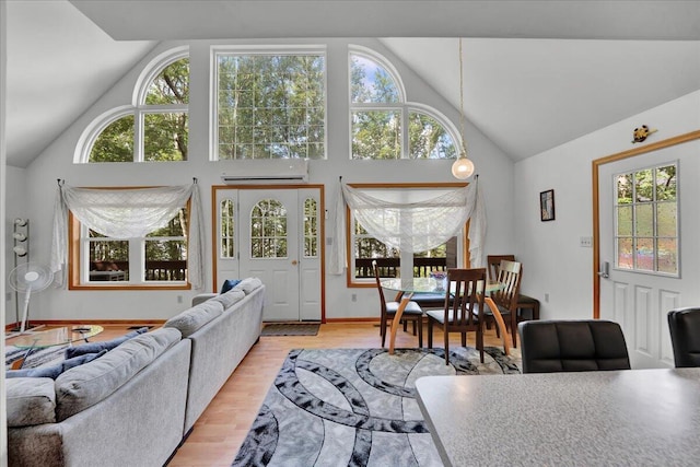 318 N Arrow Dr, Pocono Lake, PA 18347 - living room featuring plenty of natural light, a wall mounted air conditioner, high vaulted ceiling, and wood finished floors