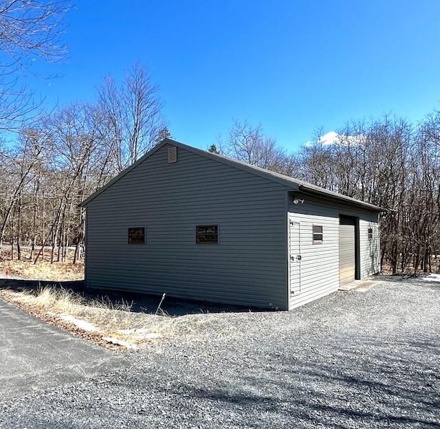 view of side of property with a garage and an outbuilding