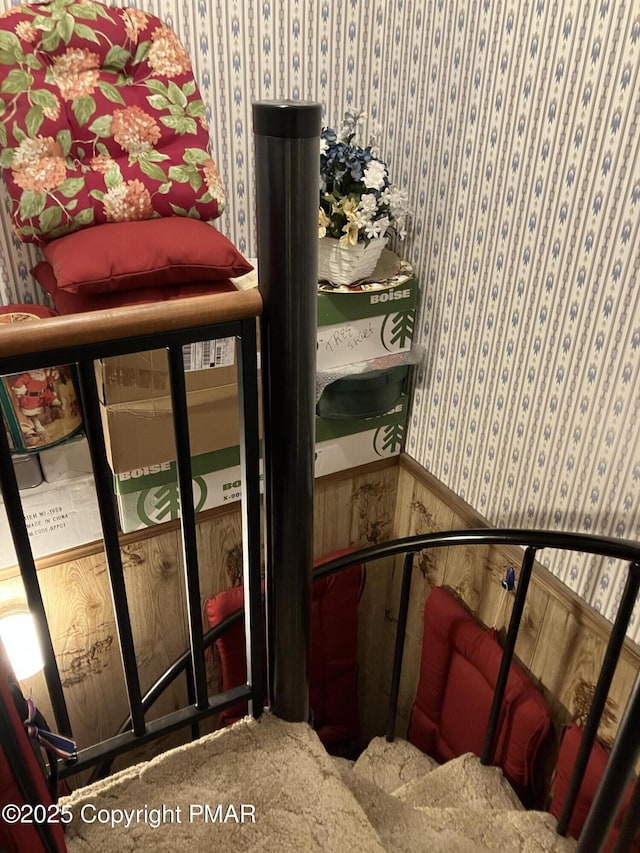 stairway featuring a wainscoted wall and wallpapered walls