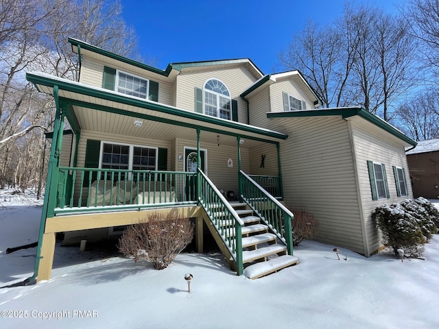 traditional-style house featuring stairway and covered porch