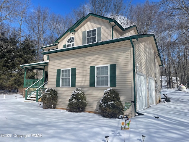 view of snow covered exterior with a garage