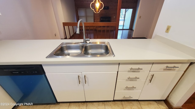 kitchen with dishwashing machine, white cabinetry, light countertops, and a sink