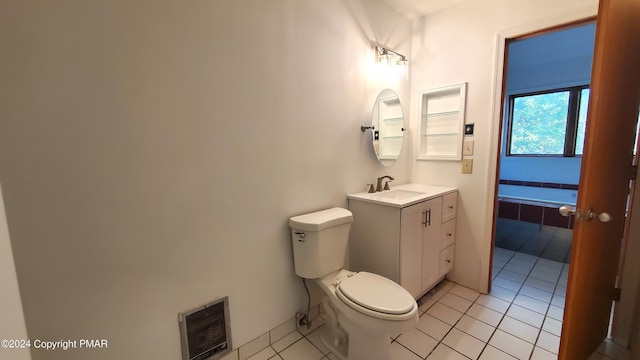 bathroom with heating unit, visible vents, toilet, vanity, and tile patterned flooring