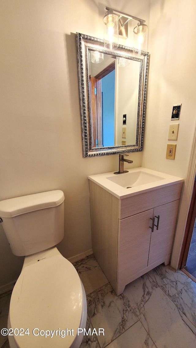 bathroom featuring marble finish floor, vanity, toilet, and baseboards