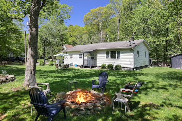 418 Leander Rd, East Stroudsburg, PA 18302 - rear view of house featuring an outdoor fire pit, a yard, an outbuilding, and a storage shed