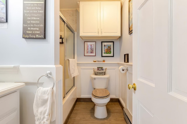 full bathroom with toilet, enclosed tub / shower combo, wainscoting, wood finished floors, and vanity