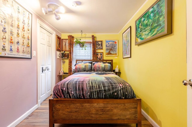 bedroom with baseboards and wood finished floors