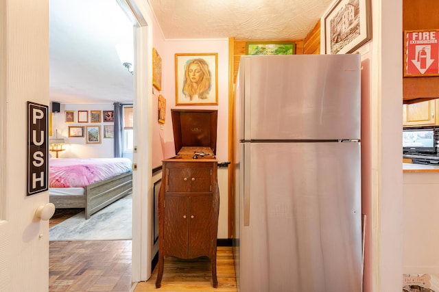 kitchen featuring parquet floors and freestanding refrigerator