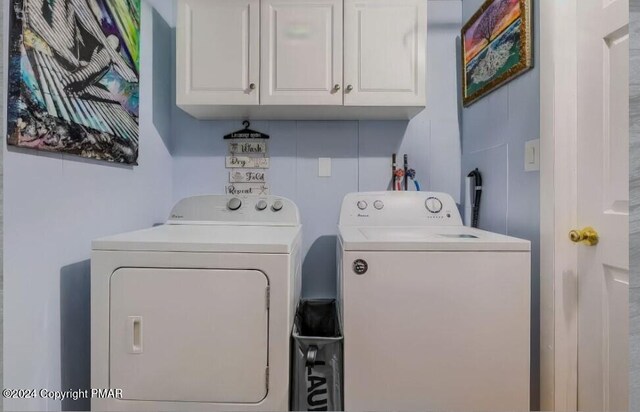 laundry room featuring washing machine and clothes dryer and cabinet space