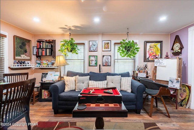 living area with ornamental molding and wood finished floors