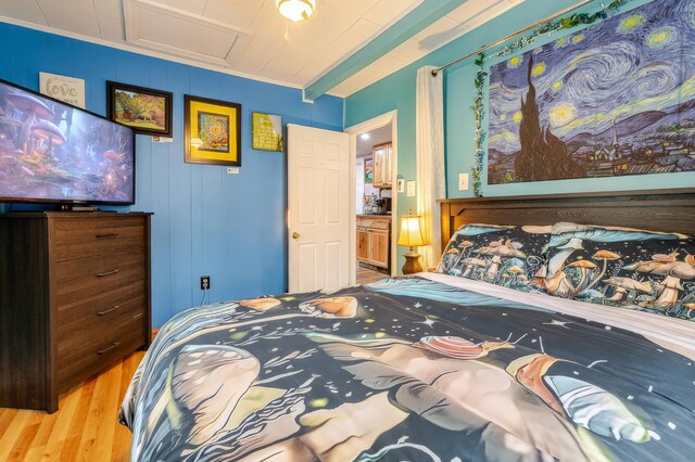 bedroom with crown molding and wood finished floors