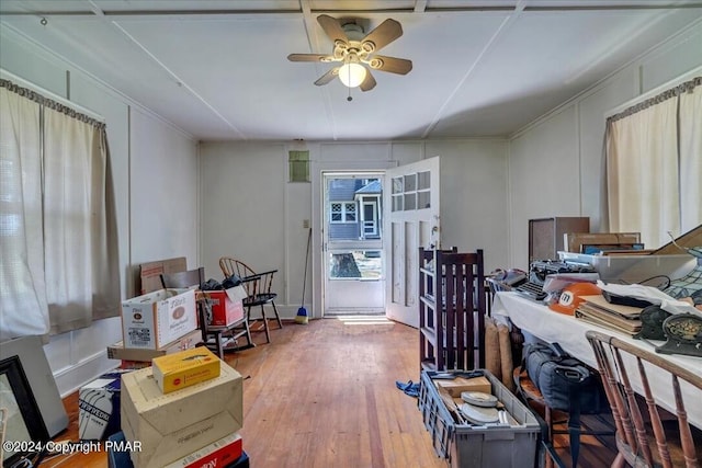 interior space featuring a decorative wall, ceiling fan, and hardwood / wood-style flooring