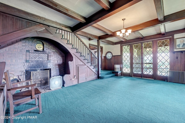 living area with a wainscoted wall, carpet floors, beam ceiling, and an inviting chandelier