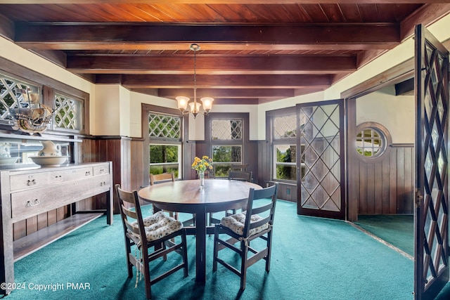 dining space featuring a wainscoted wall, wooden ceiling, and an inviting chandelier