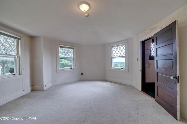 carpeted empty room featuring baseboards