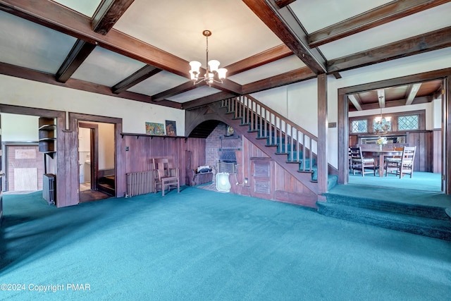 unfurnished living room featuring beam ceiling, carpet, stairs, and an inviting chandelier