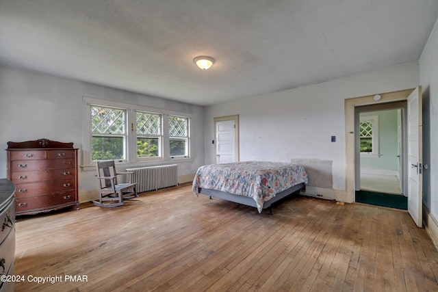 bedroom featuring light wood-style floors and radiator heating unit