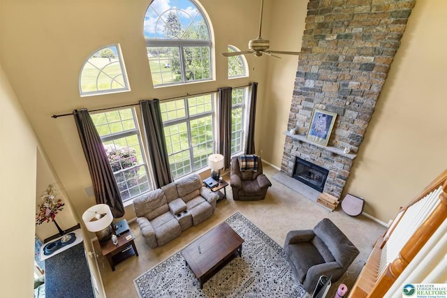 140 Birdie Way, Kunkletown, PA 18058 - living area featuring a towering ceiling, a ceiling fan, a stone fireplace, baseboards, and carpet flooring
