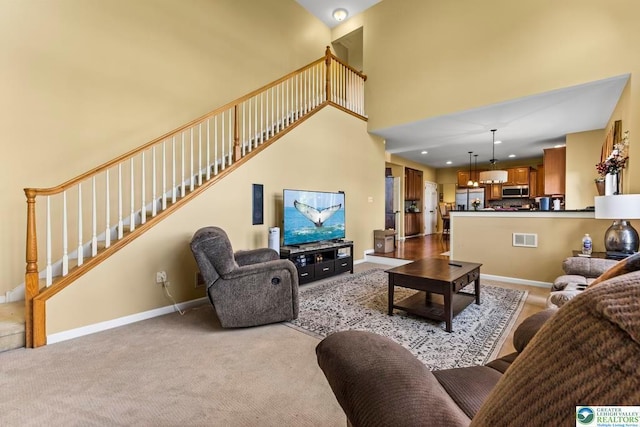 140 Birdie Way, Kunkletown, PA 18058 - living area featuring stairway, light colored carpet, a high ceiling, and baseboards