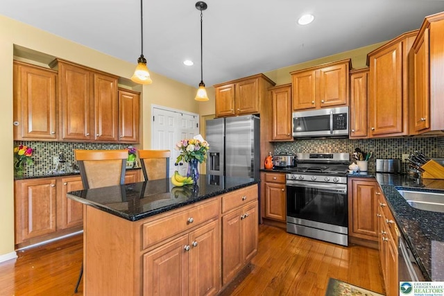 140 Birdie Way, Kunkletown, PA 18058 - kitchen with appliances with stainless steel finishes, dark wood finished floors, brown cabinetry, a center island, and decorative backsplash
