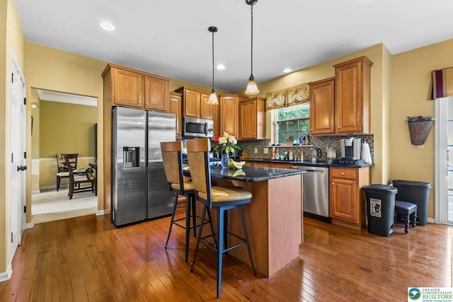 140 Birdie Way, Kunkletown, PA 18058 - kitchen featuring appliances with stainless steel finishes, dark wood-type flooring, tasteful backsplash, a kitchen bar, and a kitchen island