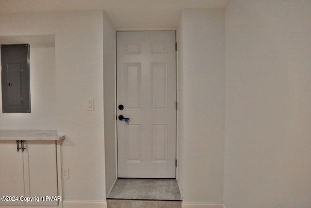 entryway featuring light wood-type flooring, electric panel, and baseboards