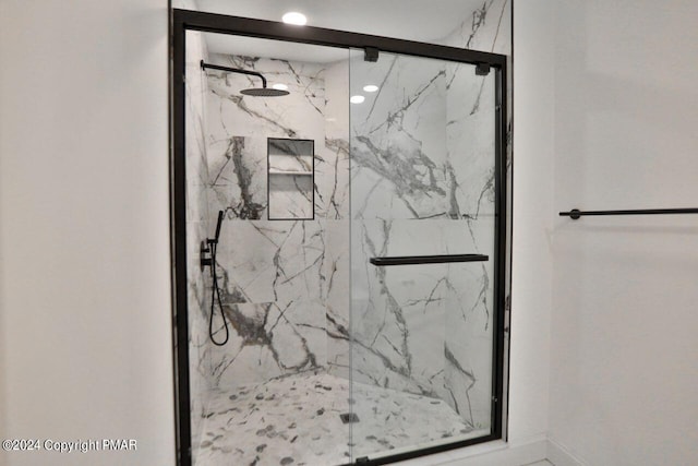 bathroom featuring a marble finish shower