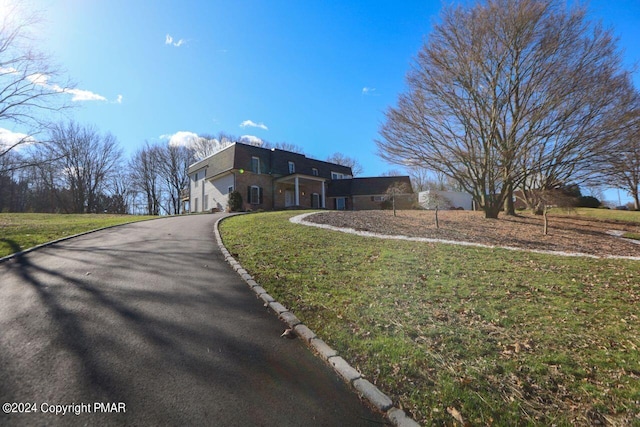 view of property exterior featuring a yard and aphalt driveway