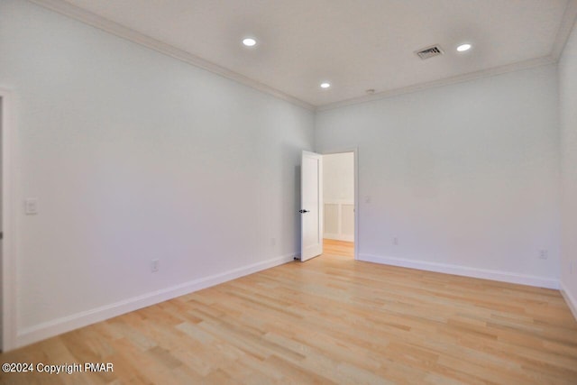 unfurnished room featuring ornamental molding, baseboards, visible vents, and light wood finished floors