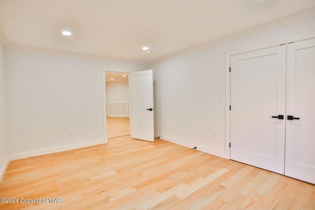 unfurnished bedroom with ornamental molding, baseboards, and wood finished floors