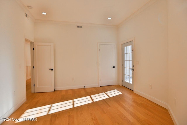 unfurnished room featuring crown molding, recessed lighting, visible vents, wood finished floors, and baseboards