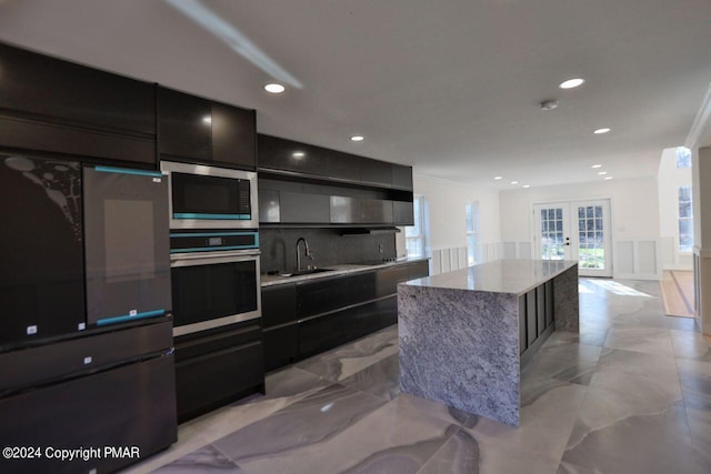 kitchen with french doors, marble finish floor, stainless steel appliances, a sink, and modern cabinets