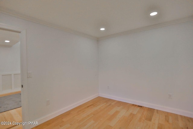 empty room featuring ornamental molding, recessed lighting, light wood-style flooring, and baseboards