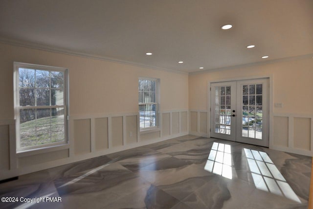 spare room featuring wainscoting, recessed lighting, a decorative wall, and french doors