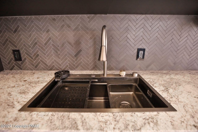 details with tasteful backsplash, a sink, and light stone counters