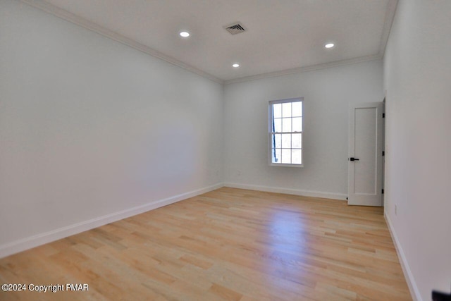 unfurnished room featuring baseboards, light wood-style flooring, visible vents, and crown molding