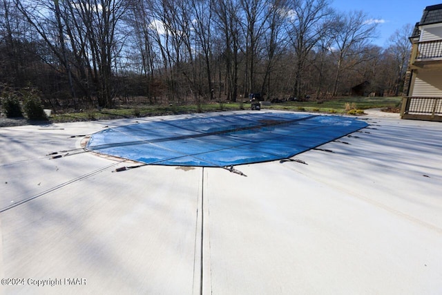 view of pool featuring a covered pool, a diving board, and a patio