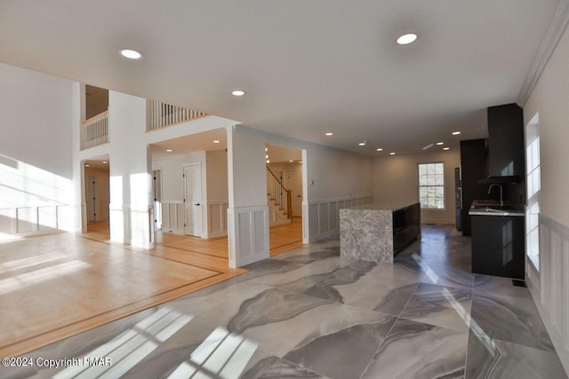 interior space featuring marble finish floor, a wainscoted wall, recessed lighting, a decorative wall, and stairway