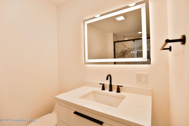 bathroom with toilet, vanity, and a shower stall