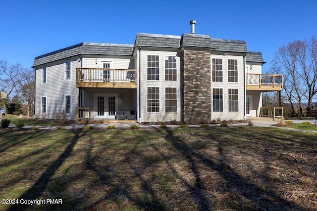 rear view of property featuring a yard, a deck, mansard roof, and french doors