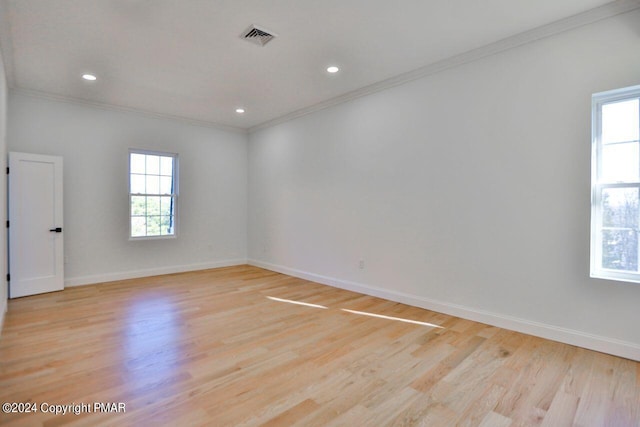 spare room featuring ornamental molding, a healthy amount of sunlight, and visible vents