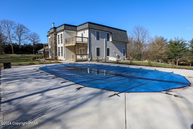 view of swimming pool featuring a patio and a covered pool