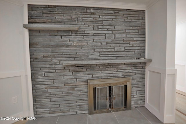 interior details featuring ornamental molding and a glass covered fireplace