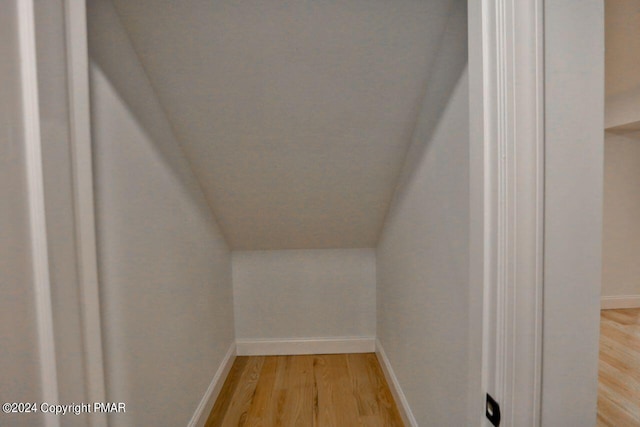 additional living space featuring lofted ceiling, baseboards, and light wood finished floors