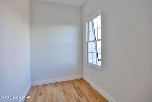 spare room with light wood-style floors, plenty of natural light, and baseboards