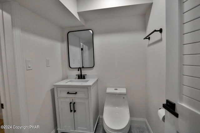 bathroom with baseboards, vanity, and toilet