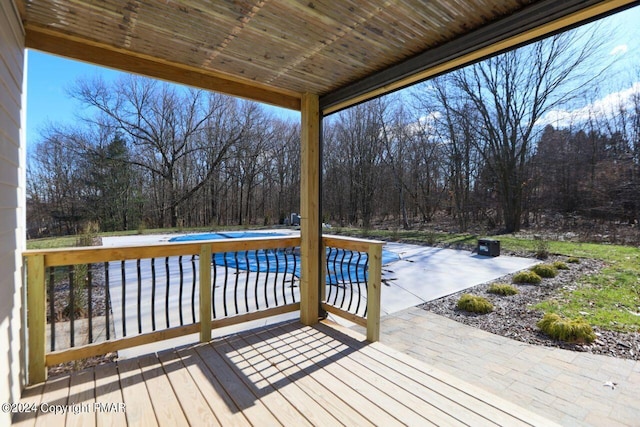 wooden deck featuring a patio area and a covered pool