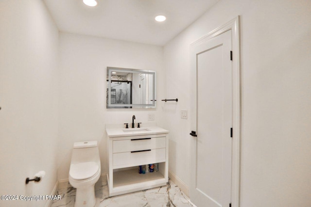 bathroom featuring marble finish floor, baseboards, and toilet