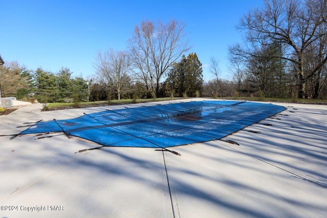 view of swimming pool featuring a patio area and a covered pool