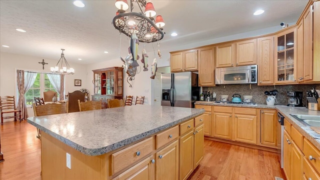 169 Roberts Rd, Starlight, PA 18461 - kitchen with stainless steel appliances, a chandelier, a center island, light wood-style flooring, and backsplash